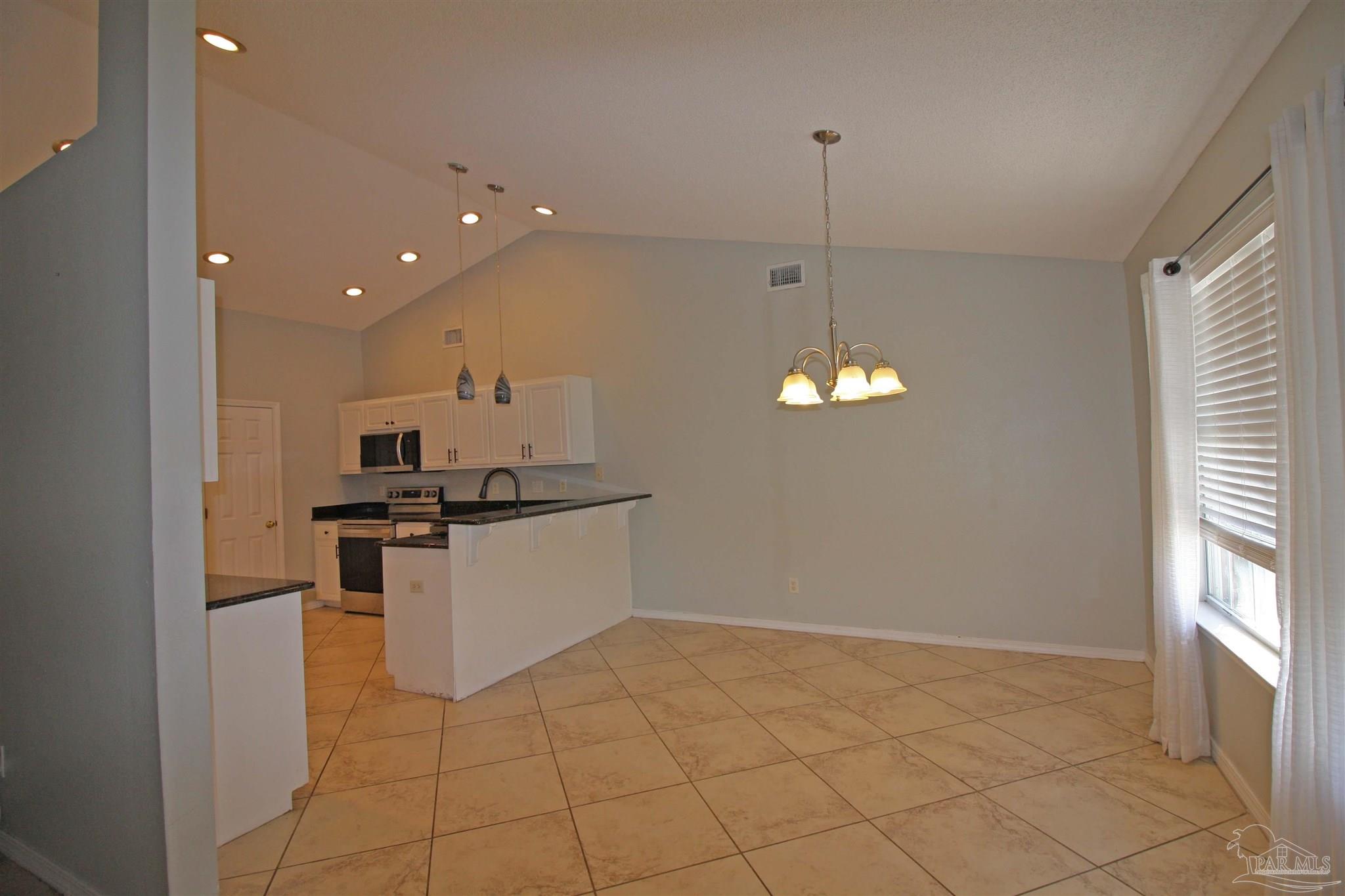 3735 Berrypatch Lane Pace, FL 32571 - Photo 21 of 46 a kitchen with stainless steel appliances granite countertop a sink a stove a refrigerator and a window