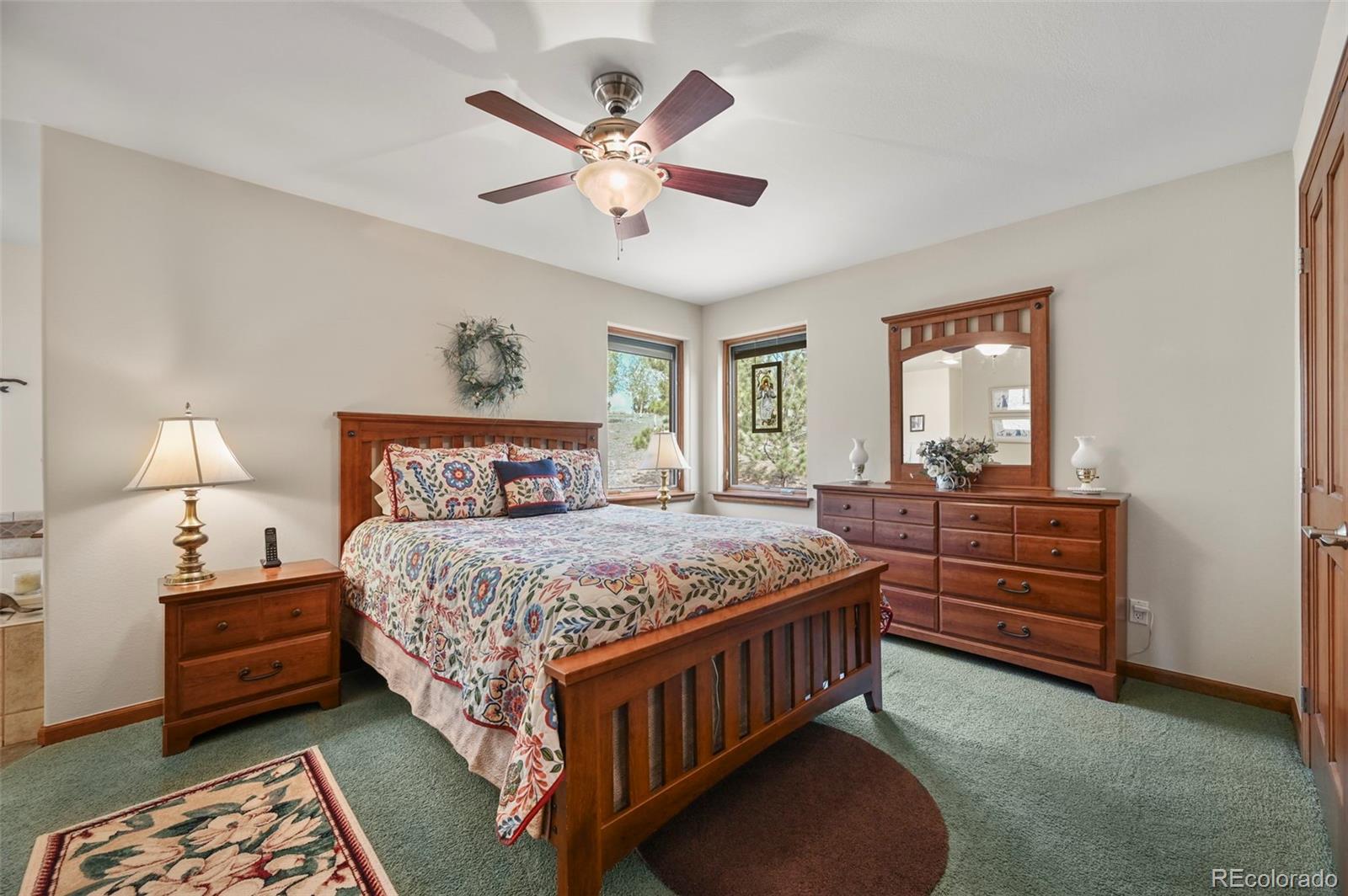 322 Sequoia Road Hartsel, CO 80449 - Photo 16 of 50 a bedroom with a bed a chandelier and dresser