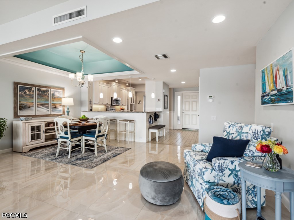 232 La Peninsula Boulevard, Unit 232 Naples, FL 34113 - Photo 9 of 44 a dining room with furniture and a chandelier