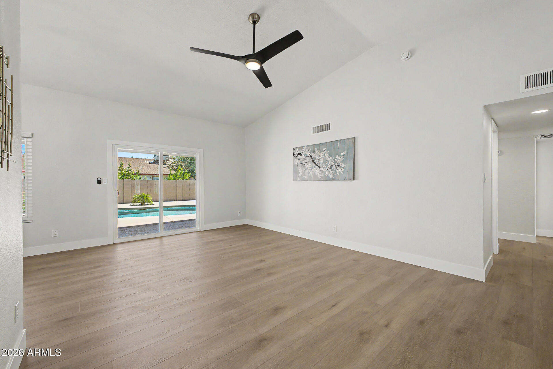 1009 West Pampa Avenue Mesa, AZ 85210 - Photo 12 of 31 an empty room with wooden floor ceiling fan and windows