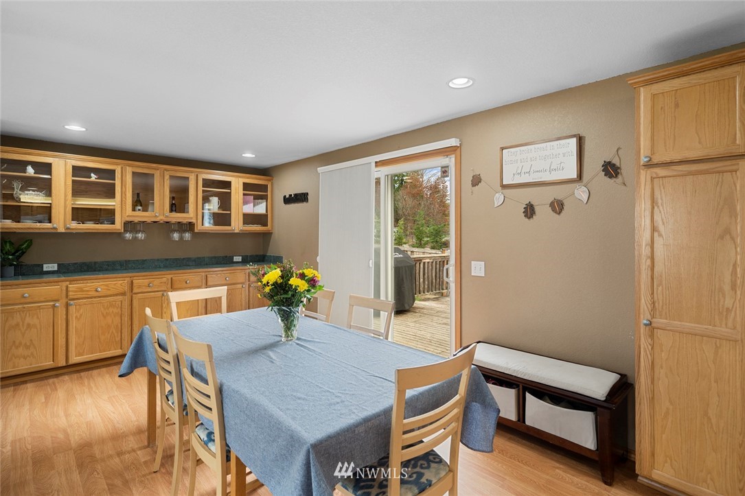 2202 179th Street Southeast Bothell, WA 98012 - Photo 6 of 31 a kitchen with a table chairs refrigerator and wooden cabinets