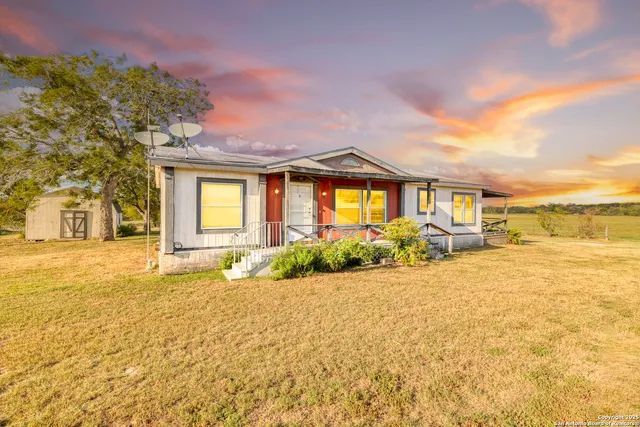 a front view of a house with a yard and lake view