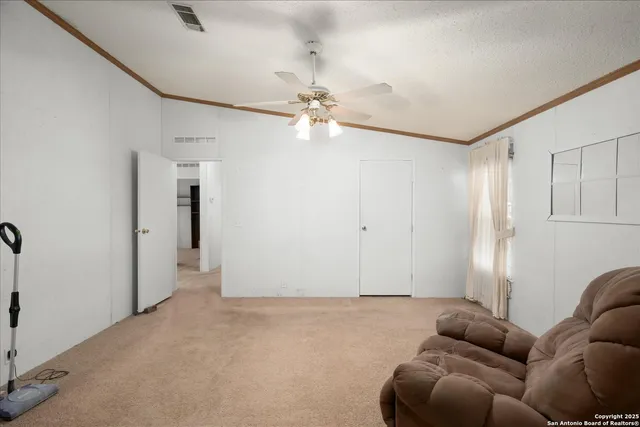 a living room with furniture and a ceiling fan