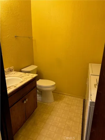 a bathroom with a granite countertop sink and a toilet