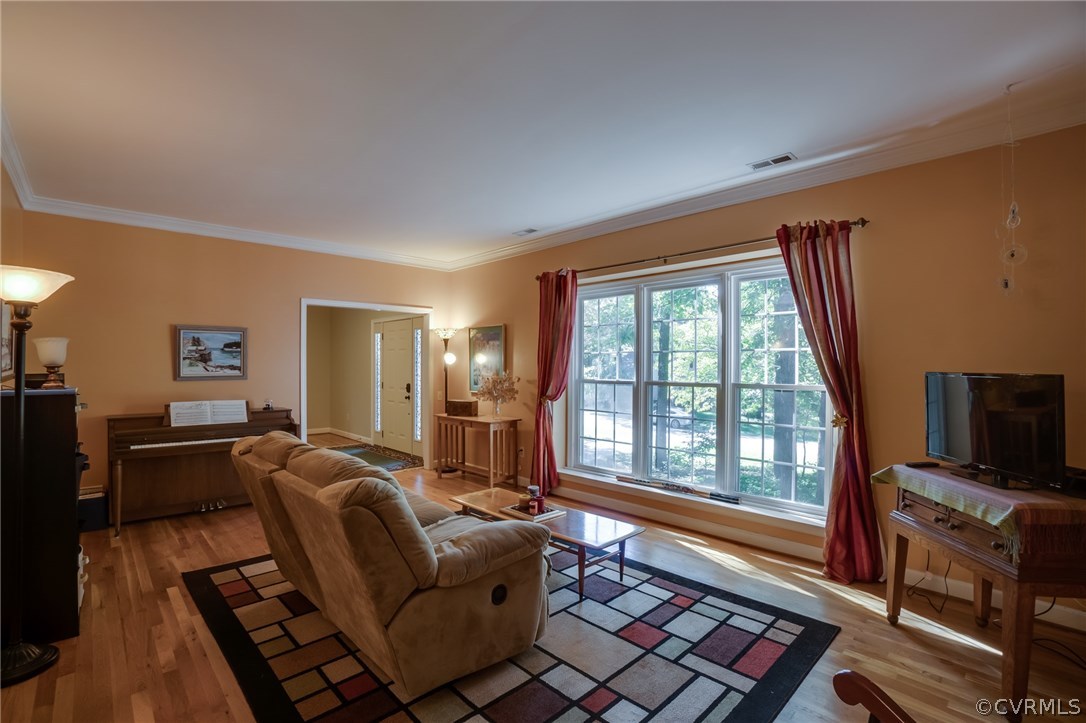 6106 Walnut Landing Way Chester, VA 23831 - Photo 8 of 41 a living room with furniture a flat screen tv and a floor to ceiling window