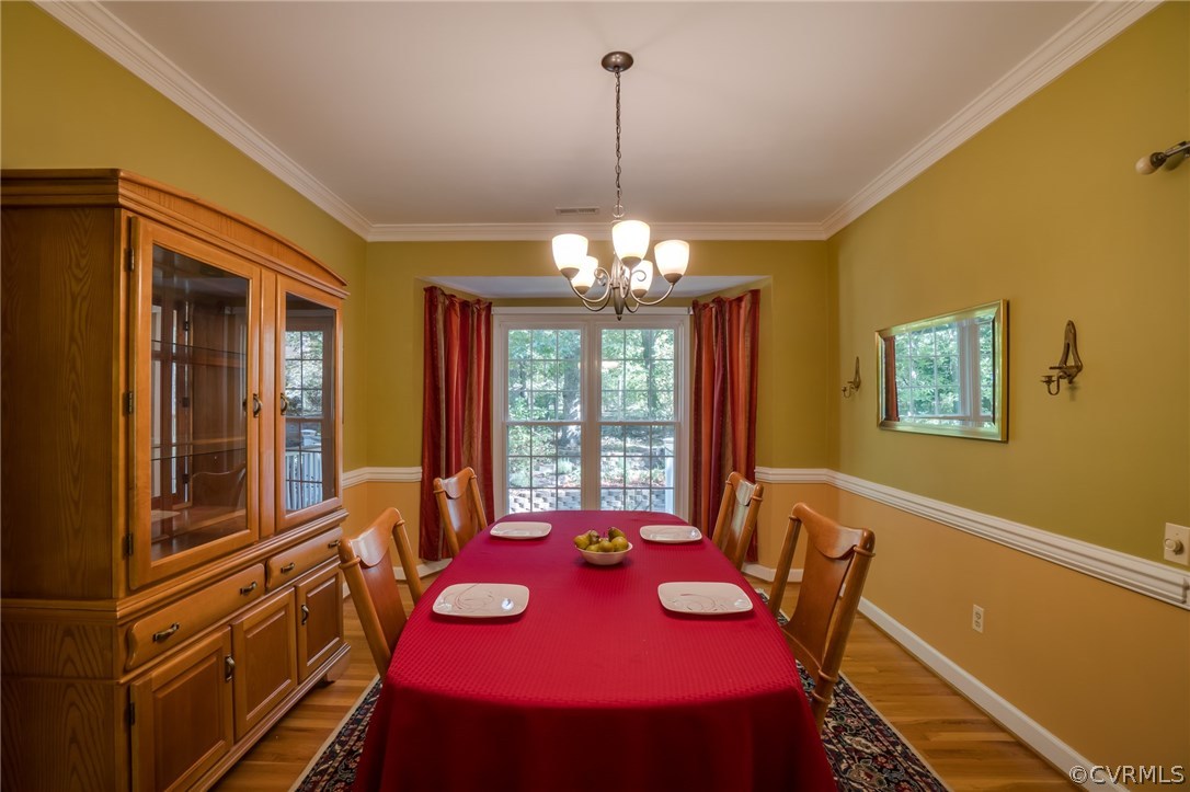 6106 Walnut Landing Way Chester, VA 23831 - Photo 9 of 41 a view of a dining room with furniture a chandelier and wooden floor