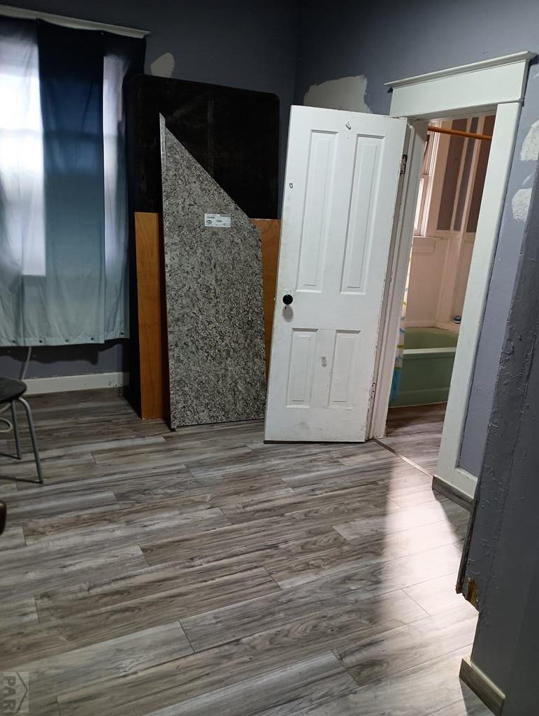 302 South 3rd Street Lamar, CO 81052 - Photo 8 of 12 a view of a room with wooden floor and white walls