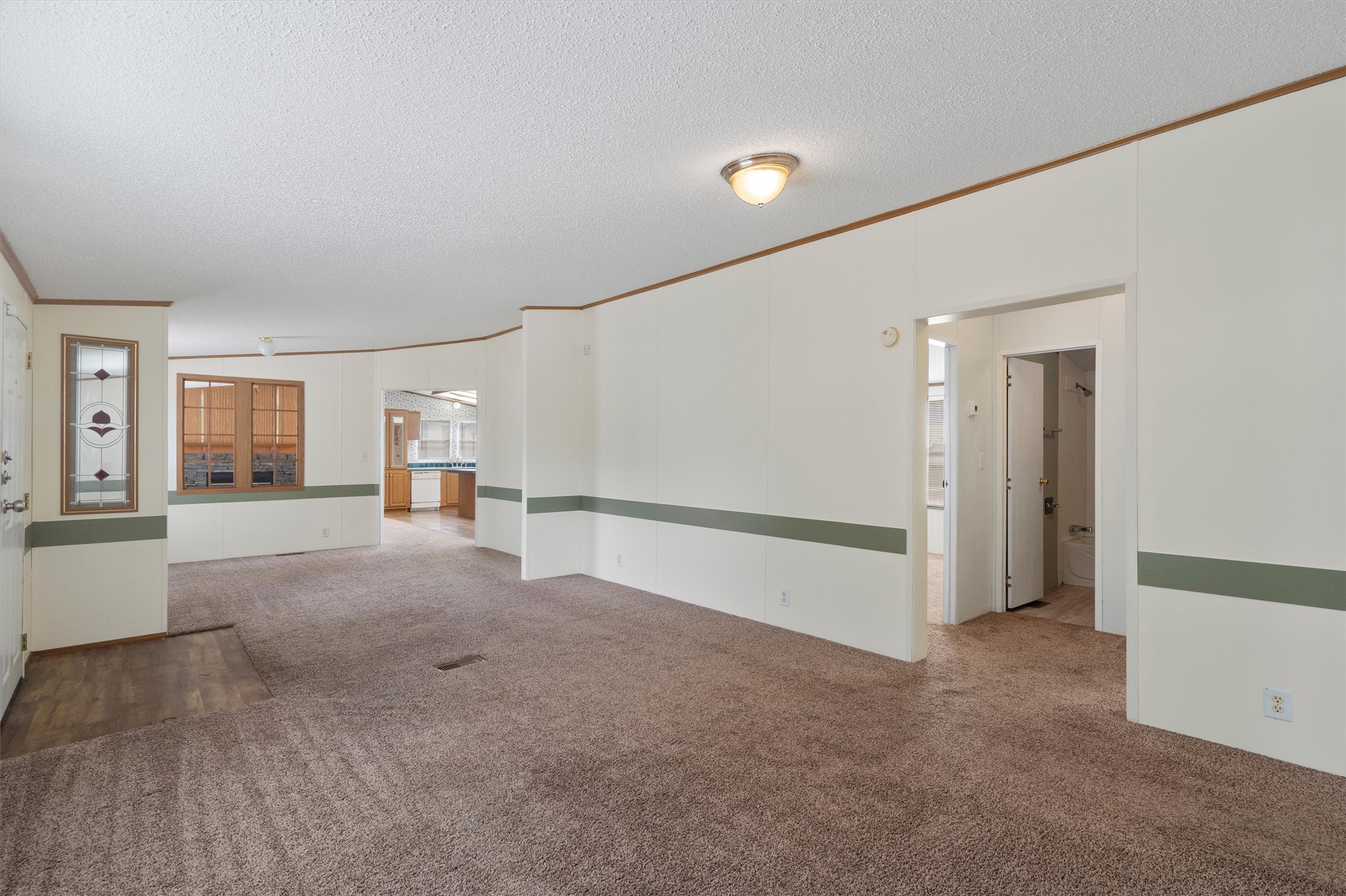 3075 Old Black Colony Road, Unit D Buda, TX 78610 - Photo 23 of 26 An open floorplan connects the carpeted living area to the adjacent kitchen and hallway.