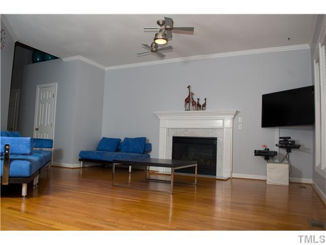 828 Cedar Downs Drive Raleigh, NC 27607 - Photo 3 of 16 a living room with furniture flat screen tv and a fireplace