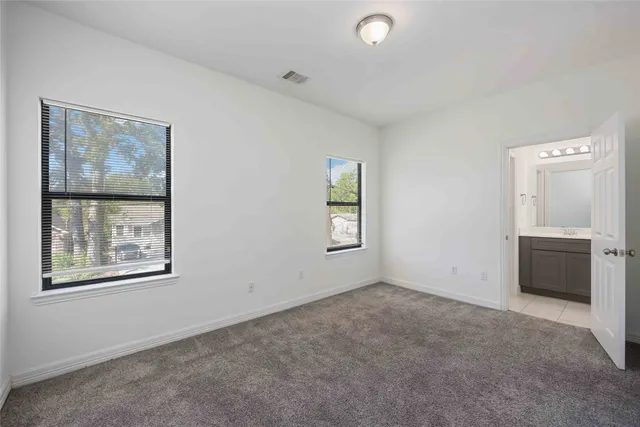 an empty room with windows and cabinet