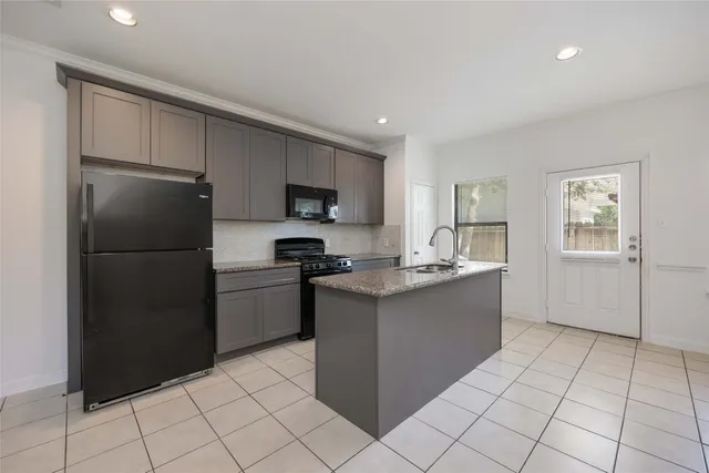 a kitchen with a refrigerator sink and cabinets