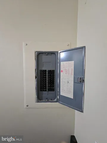 a utility room with granite countertop cabinets and a refrigerator