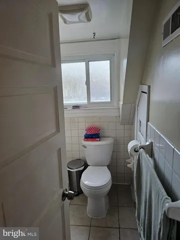 a bathroom with a sink toilet vanity and window