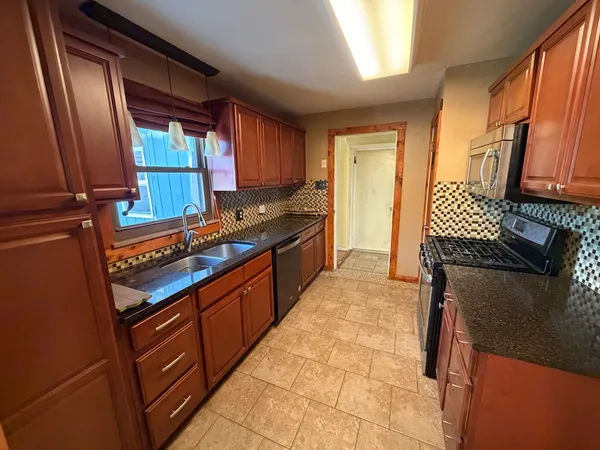 a kitchen with stainless steel appliances granite countertop a sink stove and cabinets