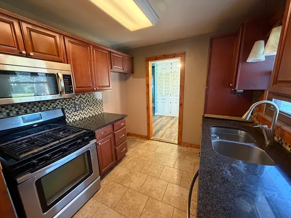 a kitchen with a stove a sink and a microwave