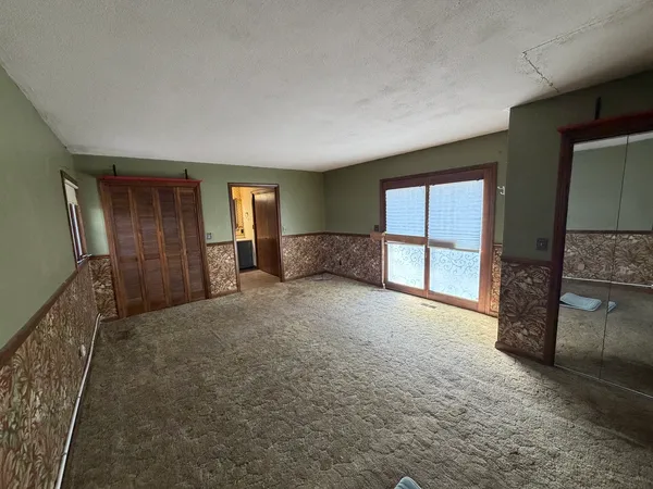 a view of an empty room with a fireplace and a window