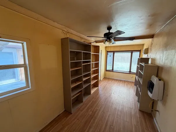 a view of a livingroom with wooden floor and a ceiling fan