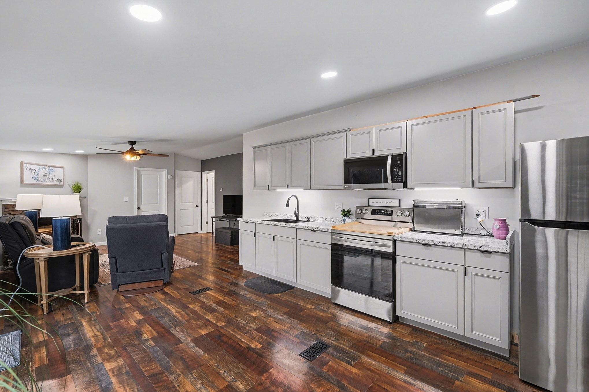 44 Opossum Hollow Road Gordonsville, TN 38563 - Photo 6 of 28 a kitchen with kitchen island a stove a sink dishwasher a refrigerator and a dining table with wooden floor