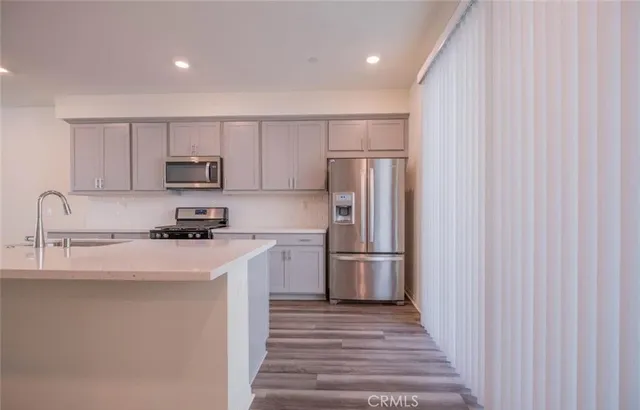 a kitchen with stainless steel appliances granite countertop a sink and wooden cabinets
