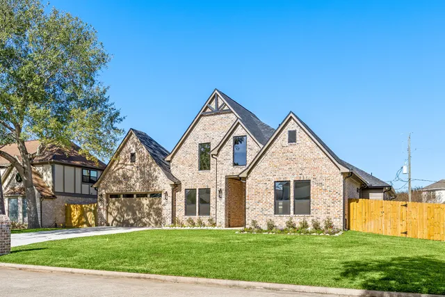 a front view of yellow house with a yard
