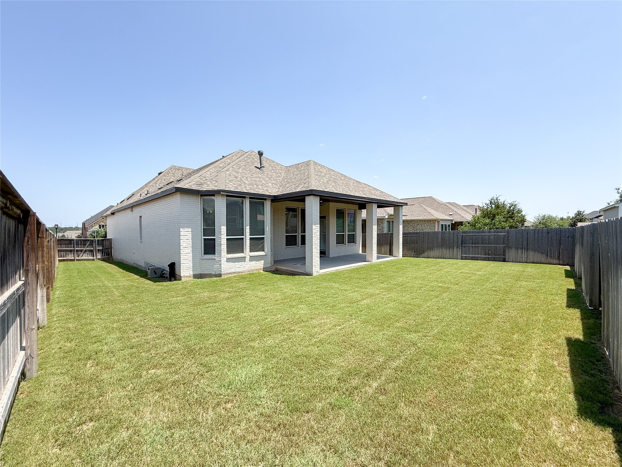 249 Heartleaf Road San Marcos, TX 78666 - Photo 32 of 38 A vast green yard complements the contemporary white brick exterior and covered patio.