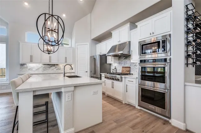 a kitchen with stainless steel appliances granite countertop a stove and a microwave
