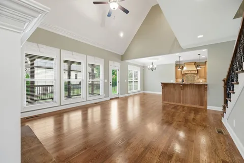 an empty room with windows and ceiling fan