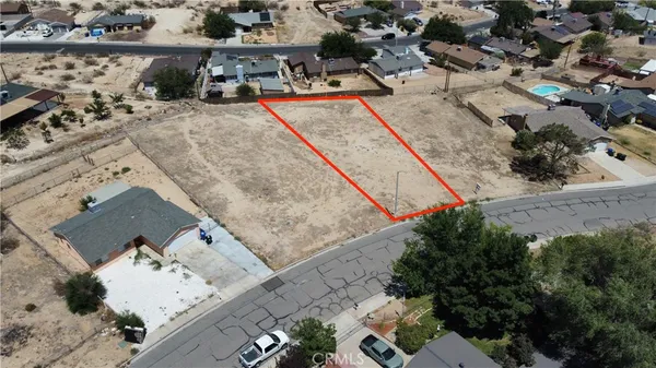 an aerial view of a house with a yard and seating space