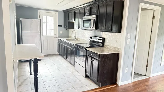 a kitchen with kitchen island granite countertop a refrigerator stove and sink