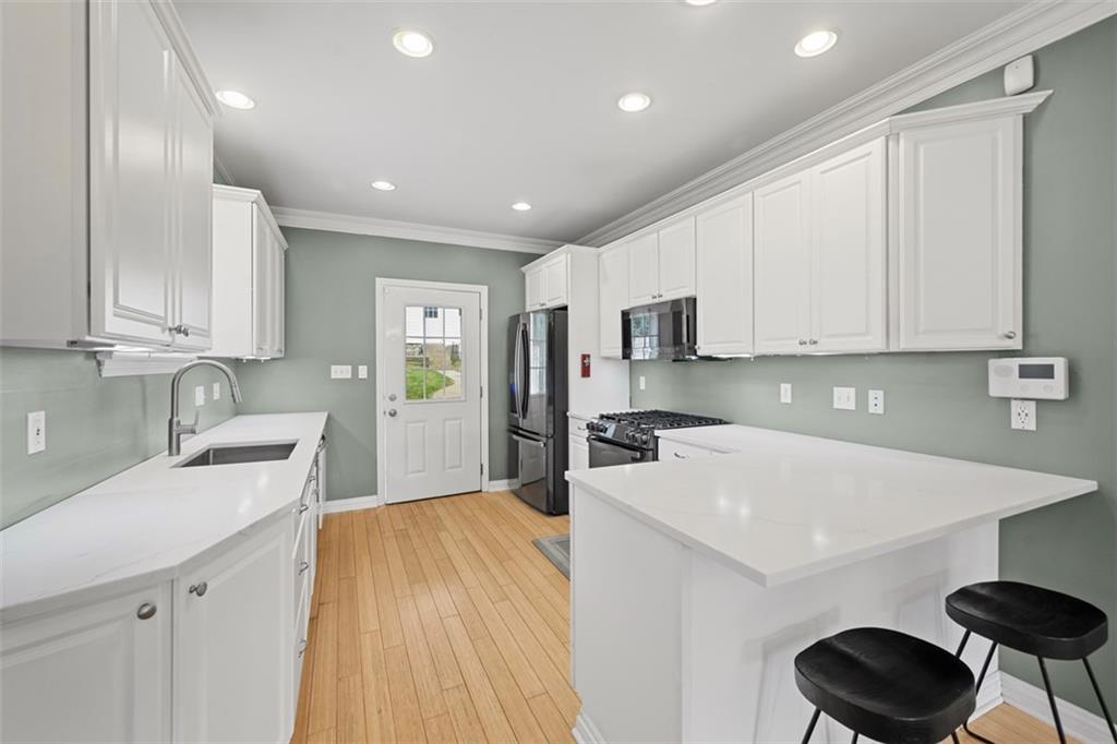 430 Hill Street Carnegie, PA 15106 - Photo 12 of 33 a kitchen with a sink a stove cabinets and wooden floor