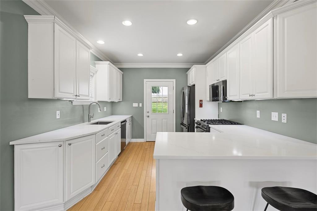 430 Hill Street Carnegie, PA 15106 - Photo 13 of 33 a kitchen with kitchen island granite countertop a sink a stove cabinets and a refrigerator