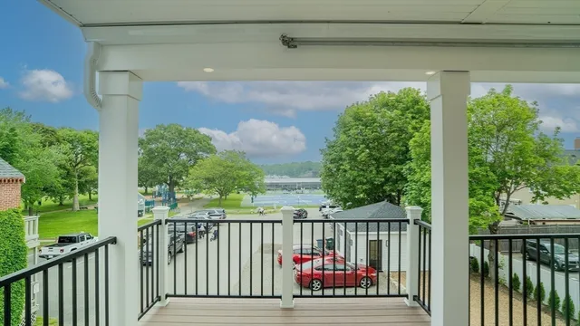 a kitchen with stainless steel appliances granite countertop a stove a sink a microwave a refrigerator and white cabinets with wooden floor