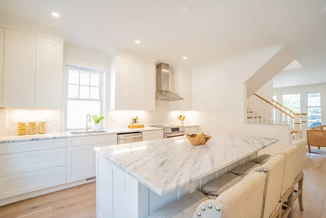 a kitchen with granite countertop a sink stainless steel appliances and cabinets