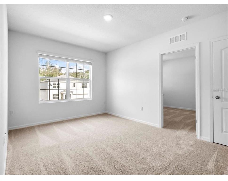 3993 Rory Oak Circle Apopka, FL 32703 - Photo 11 of 19 an empty room with wooden floor and windows