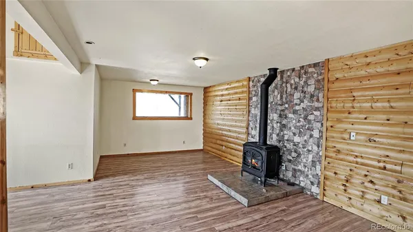 a view of an empty room with a fireplace and wooden floor
