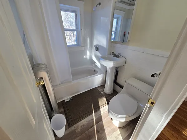 a bathroom with a toilet sink and mirror