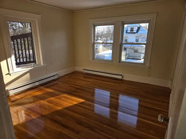 a view of wooden floor and windows in a room
