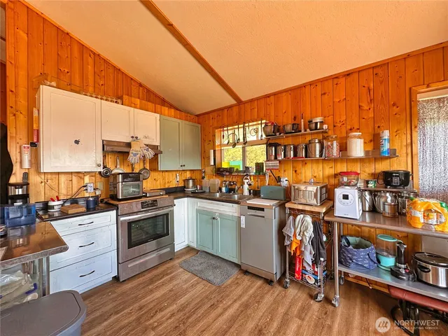 a kitchen with stainless steel appliances granite countertop a stove and cabinets