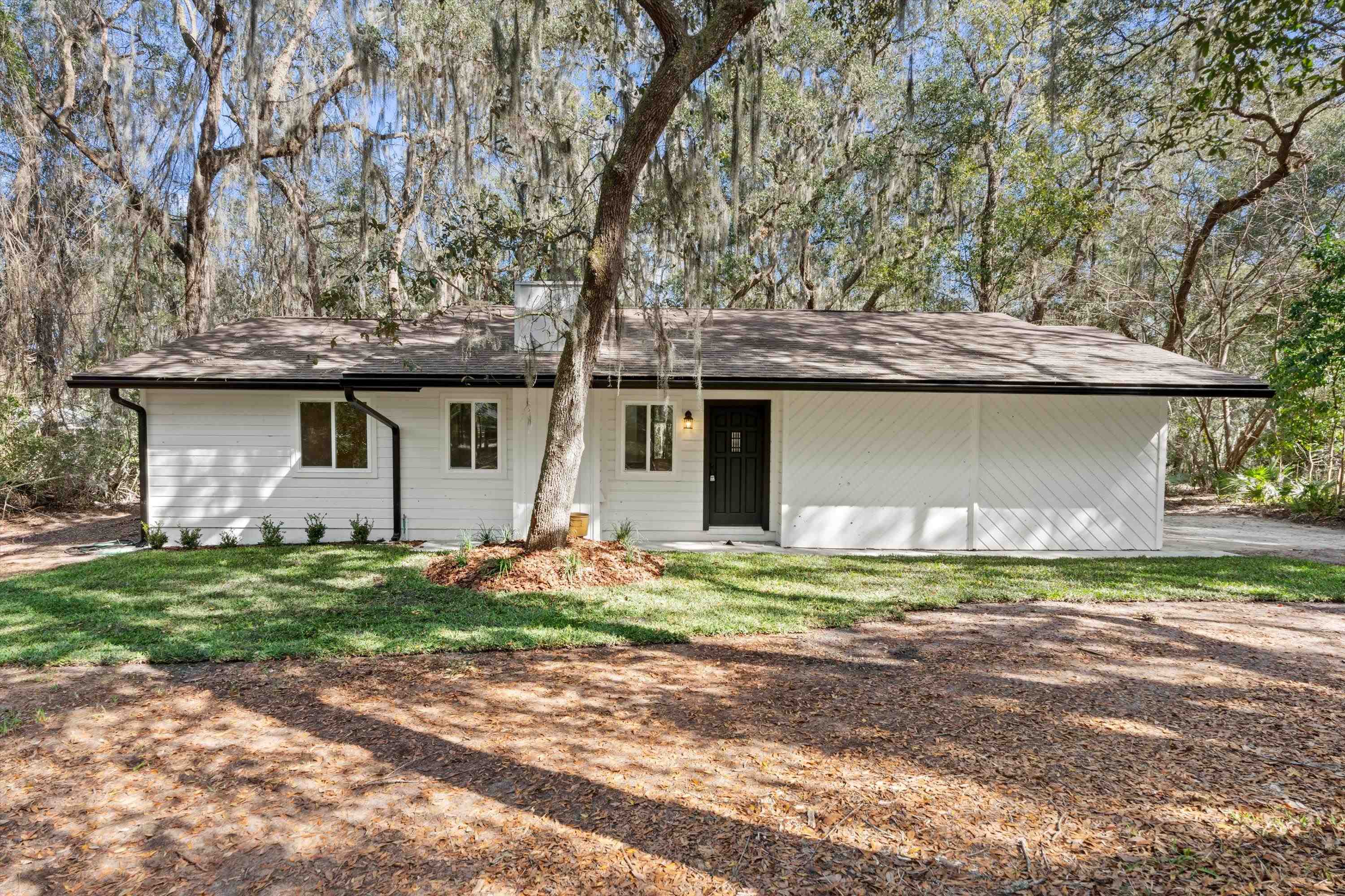 2884 Kings Road St. Augustine, FL 32086 - Photo 1 of 27 a front view of a house with a garden and trees