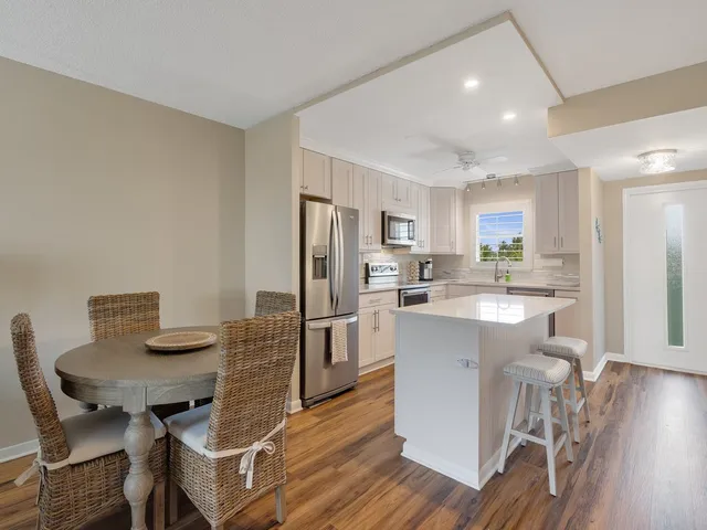 a kitchen with a table chairs refrigerator and microwave