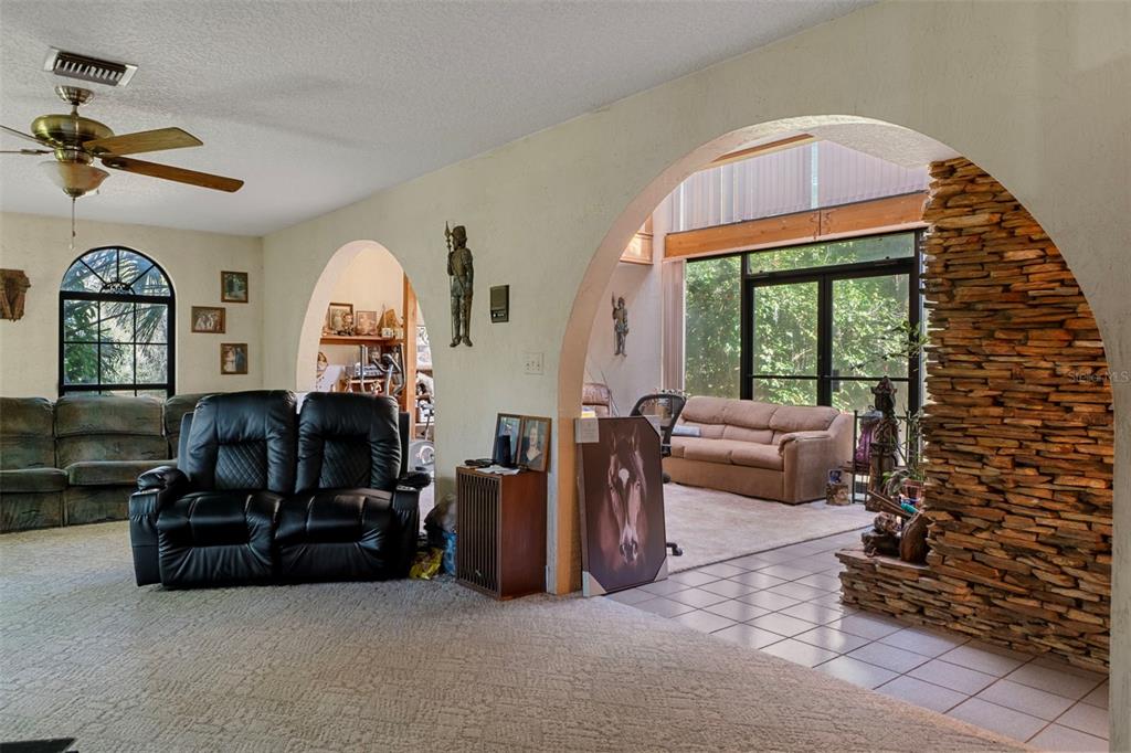 27910 Debbie Road Leesburg, FL 34748 - Photo 13 of 99 a living room with furniture a fireplace and a floor to ceiling window