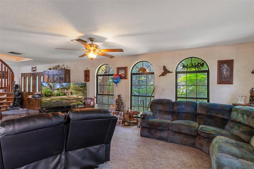 27910 Debbie Road Leesburg, FL 34748 - Photo 25 of 99 a living room with furniture fireplace and a large window
