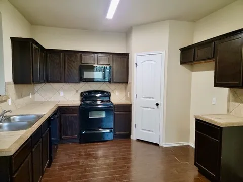 a kitchen with granite countertop a refrigerator and a sink