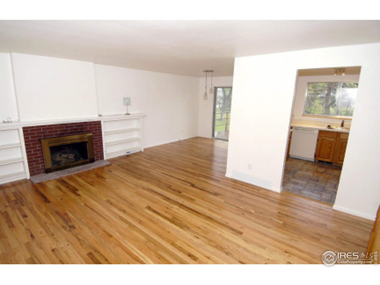 7631 Baseline Road Boulder, CO 80303 - Photo 5 of 12 a view of empty room with wooden floor and fireplace