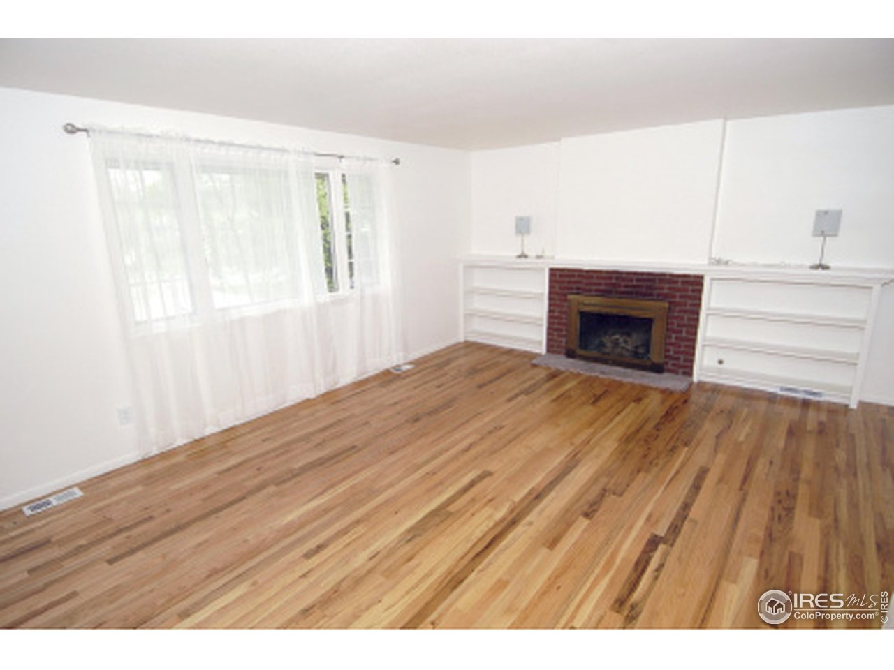7631 Baseline Road Boulder, CO 80303 - Photo 7 of 12 a view of empty room with wooden floor and fireplace