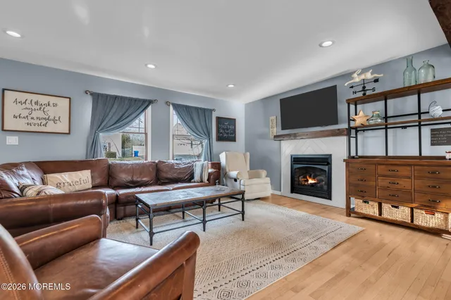 a living room with furniture a flat screen tv and a fireplace