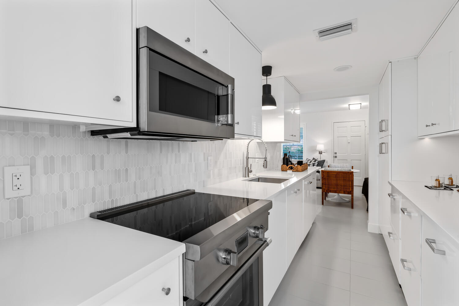 134 Peruvian Avenue, Unit 104 Palm Beach, FL 33480 - Photo 5 of 20 a kitchen with a sink dishwasher a stove and a microwave oven with white cabinets