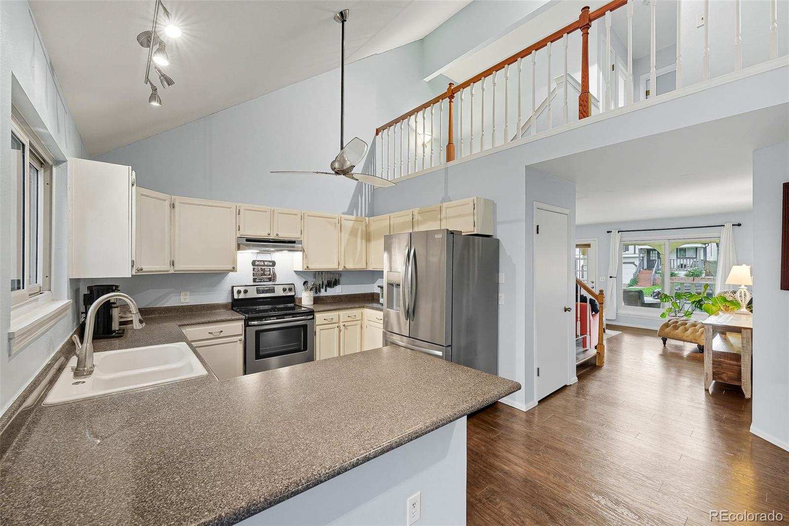 6080 Fenton Street Arvada, CO 80003 - Photo 16 of 48 a kitchen with stainless steel appliances granite countertop a refrigerator a stove top oven a sink dishwasher a dining table and chairs with wooden floor
