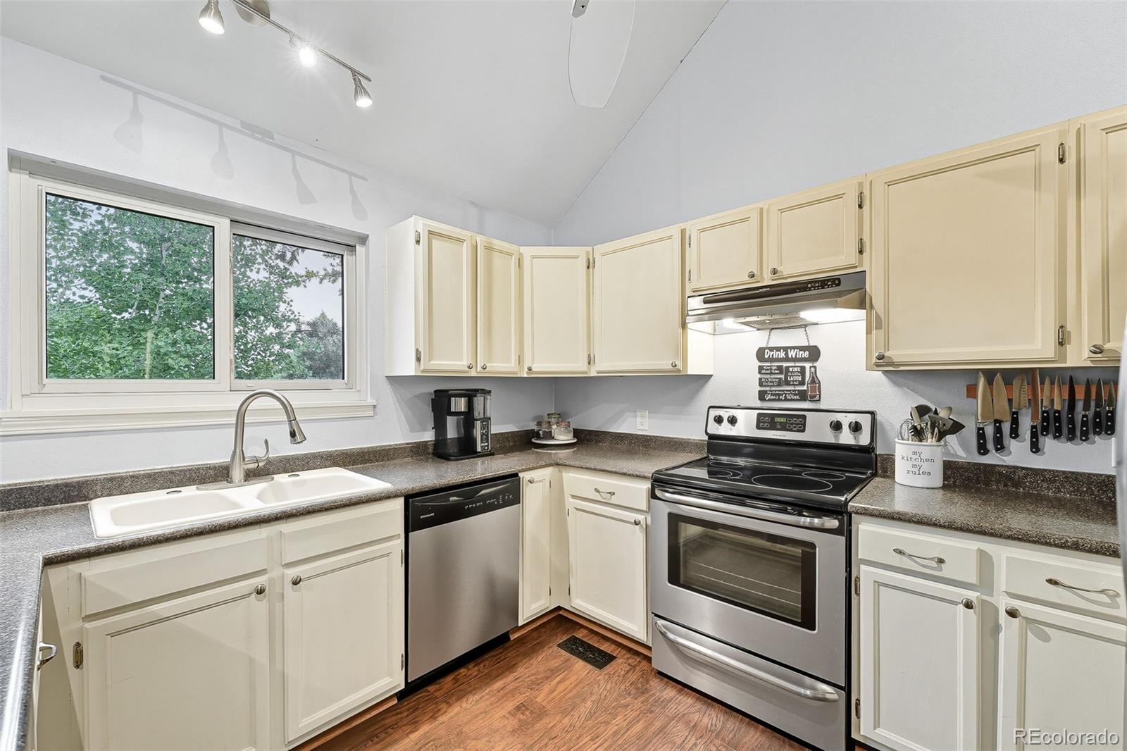 6080 Fenton Street Arvada, CO 80003 - Photo 18 of 48 a kitchen with granite countertop white cabinets and white appliances