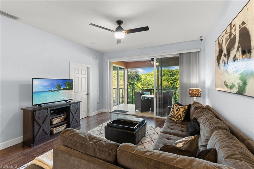 10021 Heather Lane, Unit 803 Naples, FL 34119 - Photo 11 of 41 a living room with furniture a flat screen tv and a large window